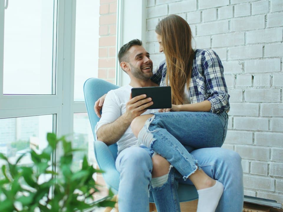 A couple looking at a tablet in their new home