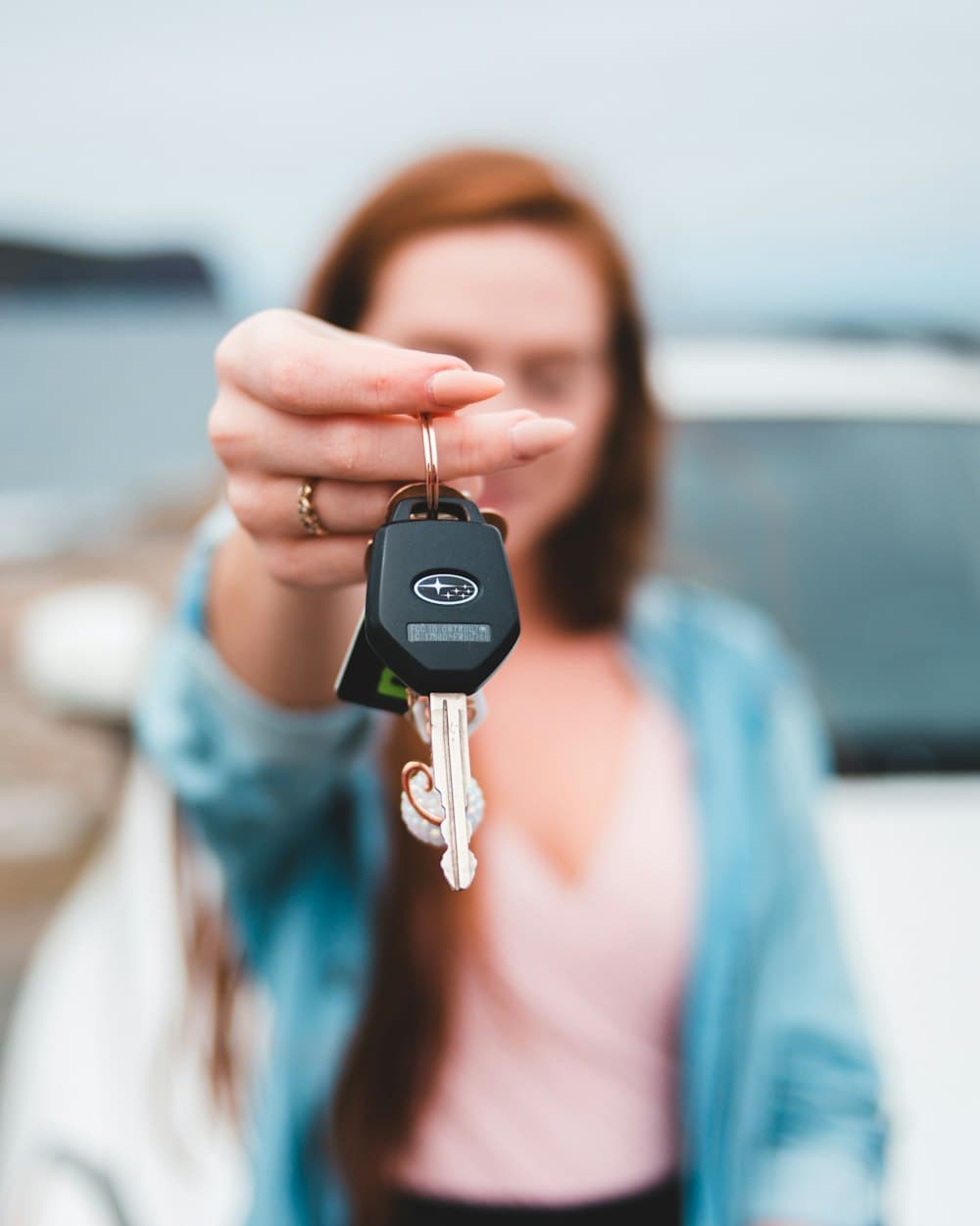 A smiling woman holding up her new car keys