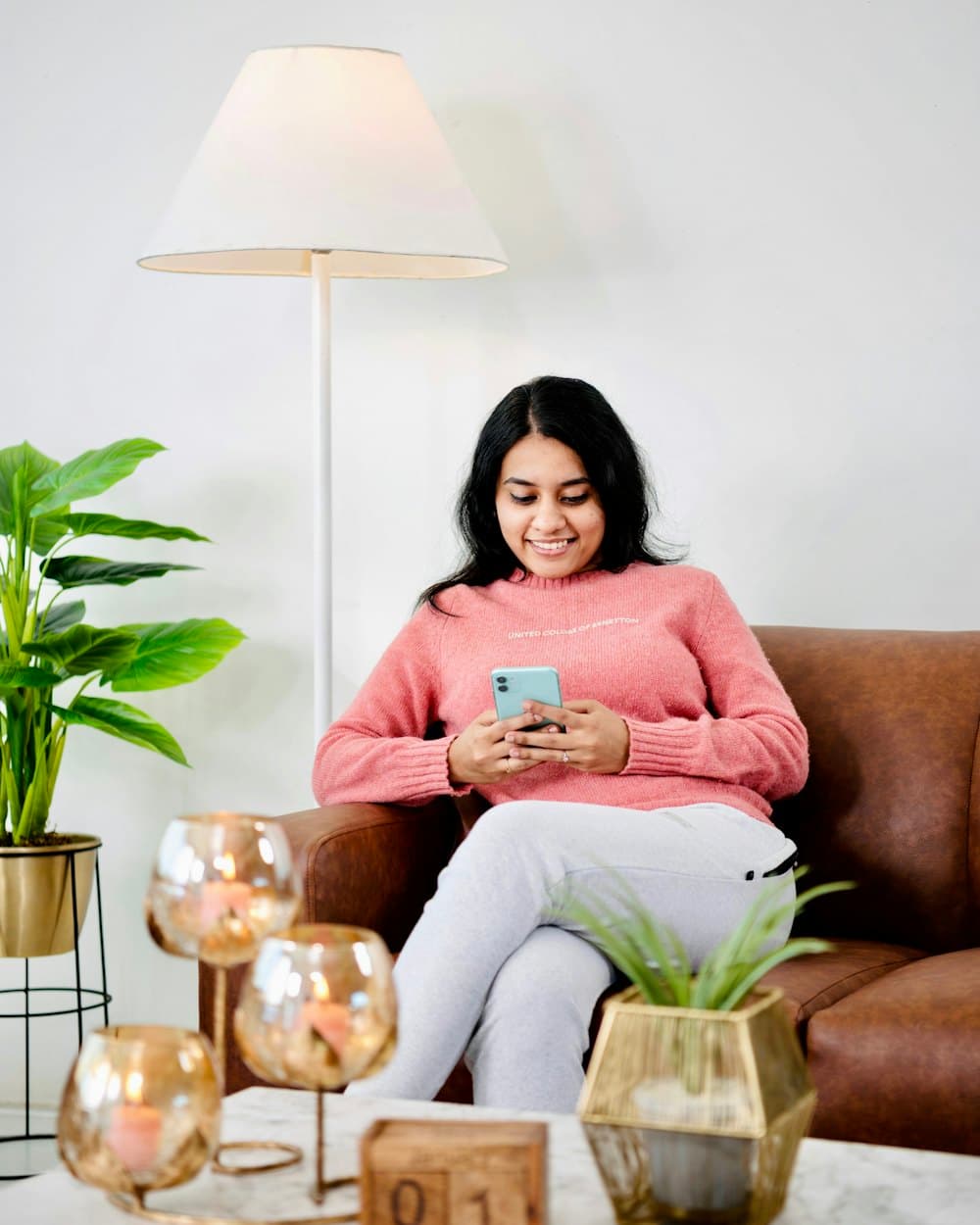 A woman on her sofa, checking her phone