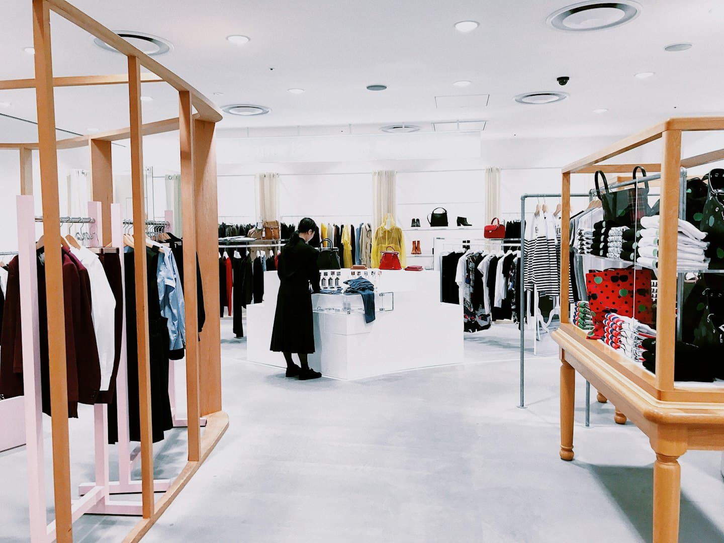 A bright clothing store with racks of clothes