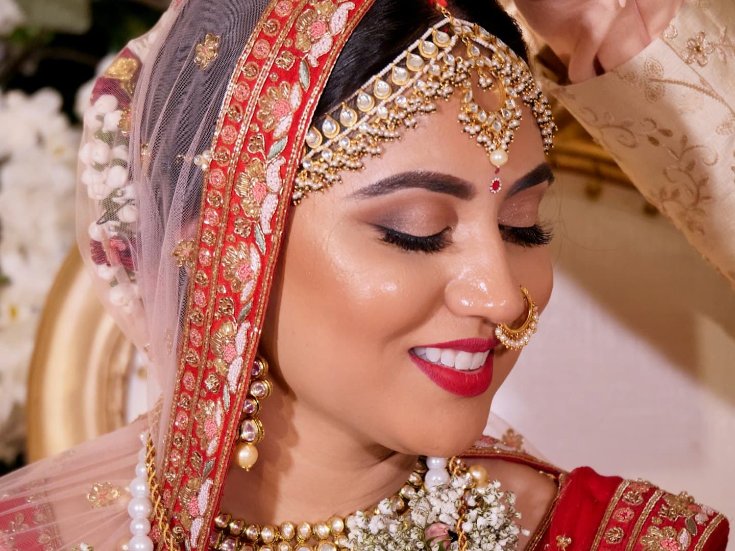A bride smiling while her makeup is done