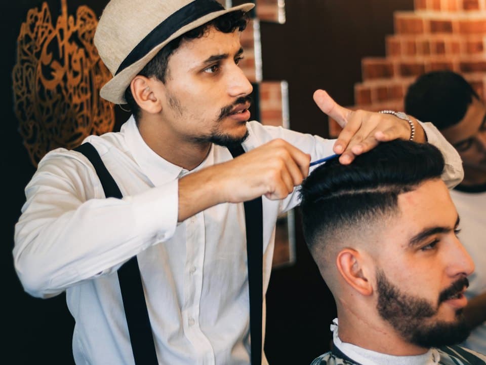 A barber styling a client's hair